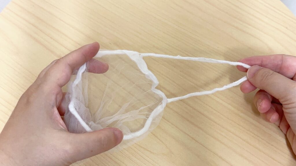 セリアのループ付き水切りストッキングネットを広げている