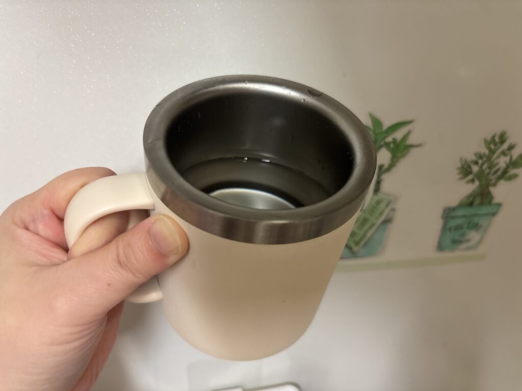ダイソー三層構造吸収タンブラーにお湯を入れて傾けている様子