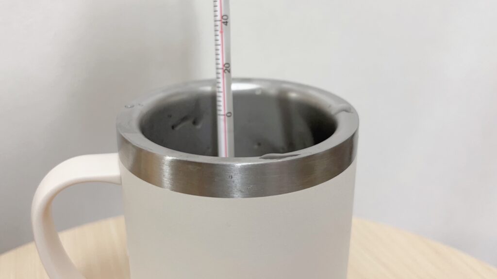 ダイソー三層構造吸収タンブラーにお湯を入れて温度計で測っている様子