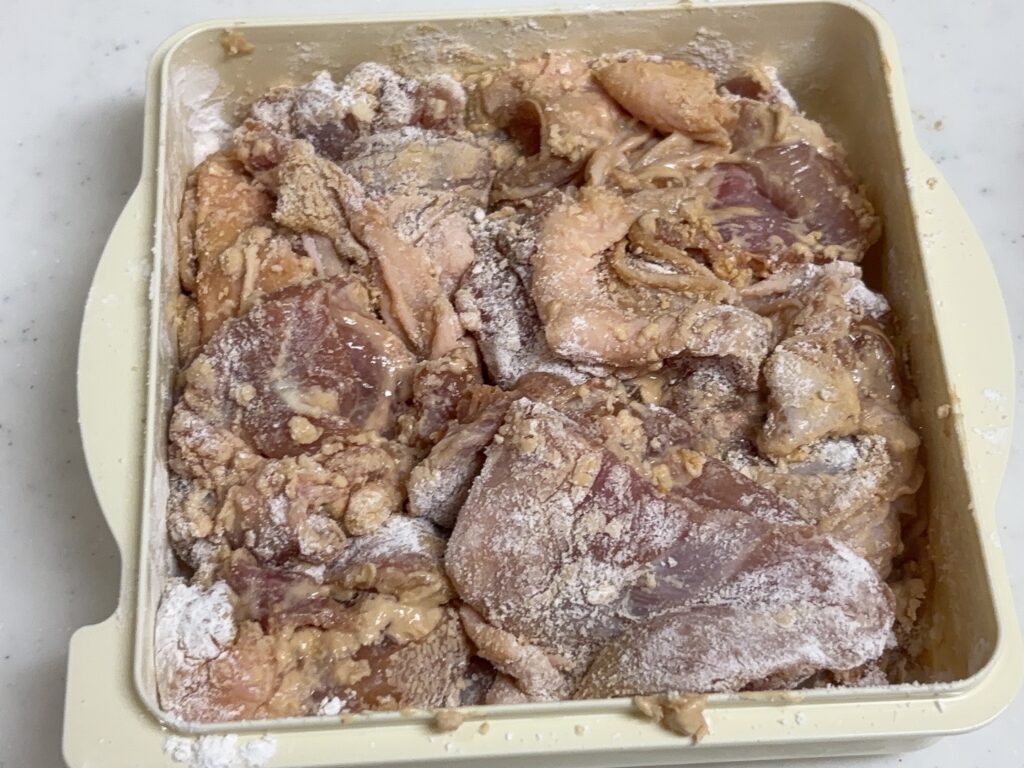 からあげ職人の外蓋に入れた粉に下味のついた鶏肉をまんべんなく付けた画像