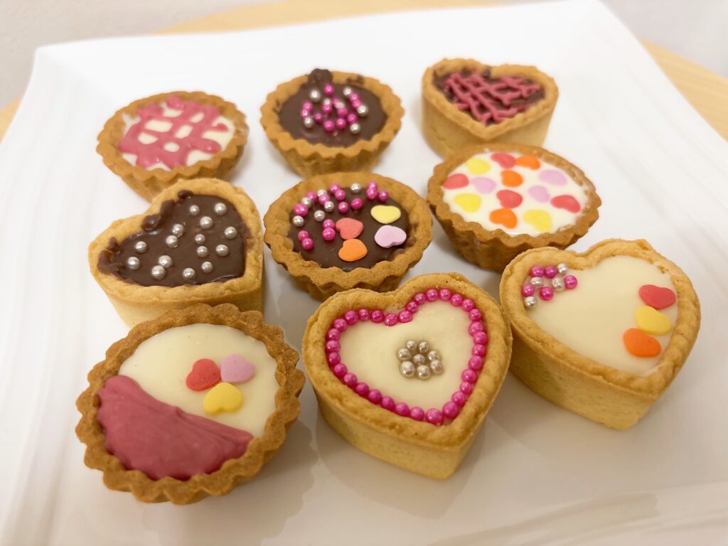 お皿にデコレーションしたタルトカップチョコを複数並べている
